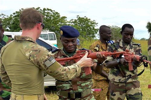 U.S. Air Force Staff Sgt. Jake Van Dyke (left), 435th Security Forces Squadron contingency response fire team member, helps a Benin airman with his weapon during the African Partnership Flight in Accra, Ghana, Sept. 14, 2016. APF is a transparent working environment between U.S. and African partner nations that builds trust and cooperation to achieve common solutions. (U.S. Air Force photo by Staff Sgt. Stephanie Longoria/Released)