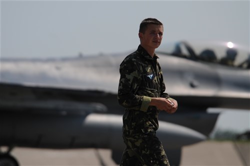 An Ukrainian airmen walks in front of an Air National Guard F-16 on the ramp of Mirgorod Air Base, Ukraine during SAFE SKIES 2011.   SAFE SKIES 2011 is a joint Ukraine, Poland, U.S. aerial exchange event promoting airspace security in preparation for the EUROCup 2012. (U.S. Air Force Photo by Maj. Matthew T. Mutti, 104FW/CCE, Released).