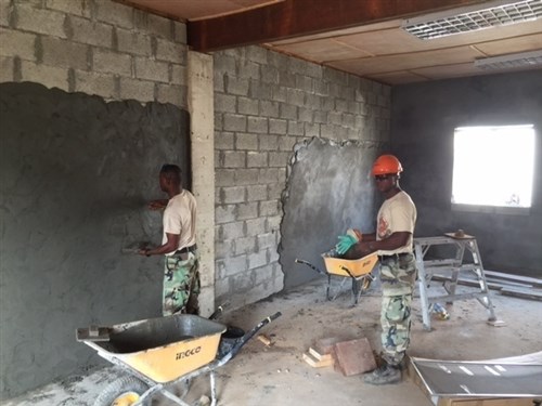 MONROVIA, Liberia - Armed Forces of Liberia Soldiers apply a cement-like mud to the interior walls of two new multipurpose buildings, Feb. 3, 2016, at the Edward Binyah Kesselly military training facility in Monrovia, Liberia. The buildings were constructed in partnership with Michigan Army National engineers during four Security Cooperation Opportunity Unit Training rotations. Maj. Gen. Gregory Vadnais, adjutant general of the Michigan National Guard, traveled to Liberia to cut the ribbon on the buildings and celebrate Liberian Armed Forces Day, Feb. 10, 2016, with the last SCOUT rotation, the MIARNG 1434th Engineer Company, AFL leaders and Liberian President Ellen Johnson Sirleaf. (U.S. Army National Guard photo by Maj. David Huber/Released)