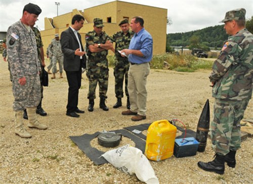 HOHENFELS, Germany &mdash; Matthew Demmitt, deputy chief of the Counter-Improvised Explosive Device Academy at the Joint Multinational Readiness Center, explains an exhibit of different types of IEDs to Serbian Land Forces Commander Lt. Gen. LjubiiÅa DikoviiÄ (at center with arms crossed) and V Corps Deputy Commanding General Brig. Gen. Michael A. Ryan (left) during the DikoviiÄ&#39;s visit to JMRC, July 29. In addition to visiting the Counter-IED Academy, DikoviiÄ toured JMRCCâ?s training facilities and received briefings designed to help Serbian forces to develop their own training facility. (U.S.Army photo by Spc. Tia Sokimson)
