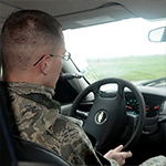Service member at the wheel of a car