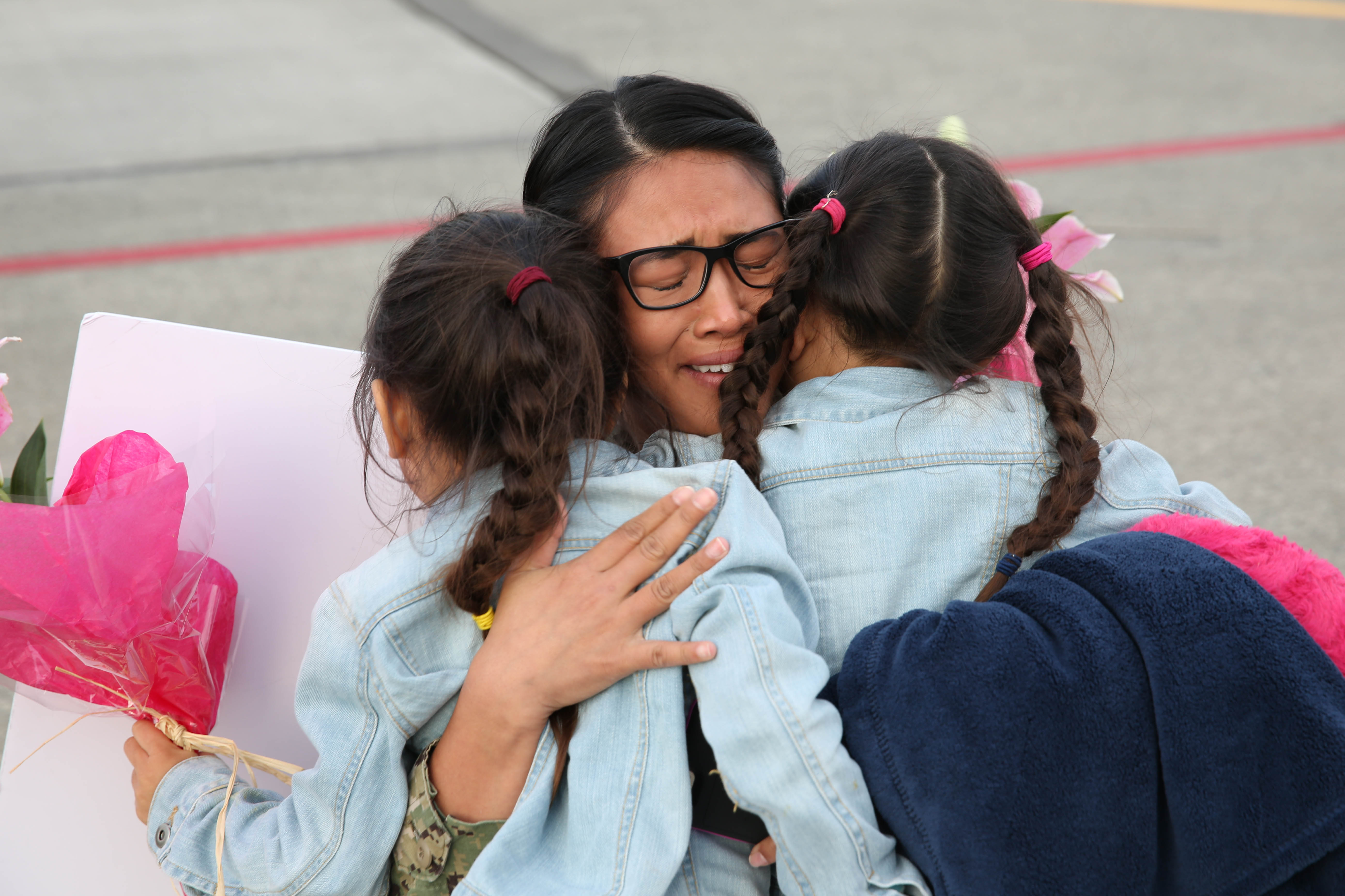 160929-N-DC740-012 OAK HARBOR, Wash. (Sept. 29, 2016) Petty Officer 1st Class Jamaica Francia, Electronic Attack Squadron 138, hugs her daughters after returning home from deployment at Naval Air Station Whidbey Island. Electronic Attack Squadron 138 conducted electronic warfare operations in the 7th Fleet area of responsibility. (U.S. Navy photo by Petty Officer 2nd Class John Hetherington/Released)

