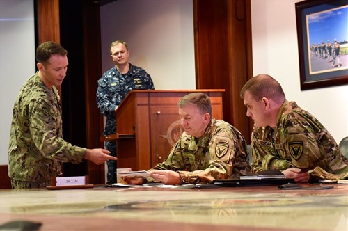 Lt. Commander Chris Casne, (left) Chief of NATO Programs for EUCOM's Logistics Directorate presents his submission to Lt. Gen. William B. Garrett III, Deputy Commander of U.S. European Command during the first EUCOM Rapid Innovation Cell forum held Feb. 2, 2016. LCDR Casne is a founding member of the ERIC and currently works as a Naval Officer within the Navy's Civil Engineer Corps. (U.S. European Command Photo by Master Sgt. Charles Larkin Sr./Released)
