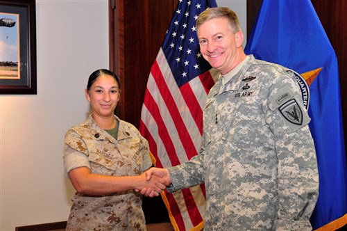 U.S. European Command Deputy Commander Lt. Gen. William Garrett III presents a coin to SSgt Luz Martinez, Executive Assistant, for exceptional duty performance.