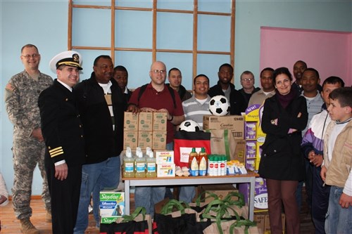 VLORA, Albania &mdash; Crew members from the USS John L. Hall (FFG 32) along with the school superintendant and students stand in the gymnasium here after a Project Handclasp donation at a special needs school, March 23. All of the children who are enrolled have learning of behavioral disorders that prevent them from enrolling in other public schools. (Department of Defense photo)