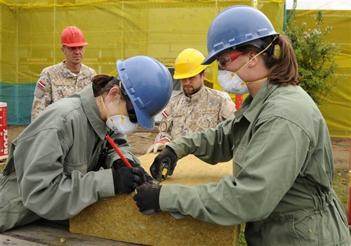 Staff Sgt. Amanda Turnwald, 127th Civil Engineering Squadron engineering assistant, marks a measurement on a piece of rock wool insulation at a kindergarten in Silmala, Latvia on June 23, 2016. The school is currently undergoing a Humanitarian-civic assistance project to provide the school with up to date renovations. (U.S. Air National Guard photo by Senior Airman Ryan Zeski)