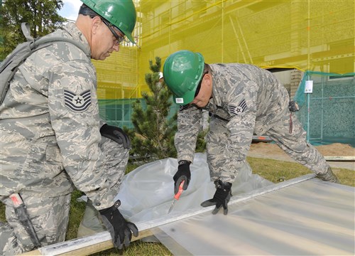 Tech. Sgt. Ken Wilson, 127th Civil Engineering Squadron HVAC supervisor and Staff Sgt. Jared Brunsen, 127th CES HVAC expert, cut sheet plastic at a kindergarten in Silmala, Latvia on June 18, 2016. The school’s renovations are part of a Humanitarian-Civic Assistance project. The project provides training opportunities for the United States and Latvian soldiers as well as a benefit for the local community. (U.S. Air National Guard photo by Senior Airman Ryan Zeski)