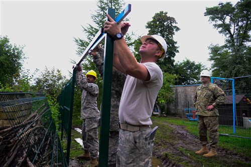 (From left to right) U.S. Army Pfc. Timmey Turner, U.S. Army Spc. Jimmy Martin and U.S. Army Staff Sgt. Jason Pionke, assigned to the 375th Engineer Company, 467th Engineer Battalion, 926th Engineer Brigade, 412th Theater Engineer Command, assist with constructing a fence during a Humanitarian Civil Assistance (HCA) project, in Sauliai, Lithuania, August 18, 2016. As part of the European Command’s (EUCOM) Humanitarian and Civic Assistance Program, the 375th Engineer Company, 457th Civil Affairs Battalion and the Lithuanian military collaborate to renovate the fence at Kudikiu Namai, an orphanage for Lithuanian children up to the age of 6, in Sauliai, Lithuania, August 8-26, 2016. (U.S. Army Photo by Pfc. Emily Houdershieldt)