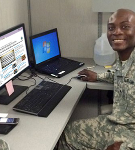 Service member at computer with Blended Retirement System training on screen