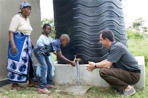 A boy washes his hands with clean water provided by water catchments at the Gombero Dispensary, Tanga, Tanzania, Dec 8, 2014. U.S. Navy Lt. Timothy Palik, right, Combined Joint Task Force-Horn of Africa Tanzania country engineer,  coordinated a project to construct the water catchments as part of the U.S. Africa Command Humanitarian Assistance Program. (U.S. Air Force photo by Staff Sgt. Carlin Leslie)