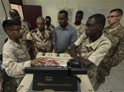 U.S. Marine Corps Cpl. Nehemias Bailon, Combined Joint Task Force-Horn of Africa, Africa Data Sharing Network (ADSN) help desk lead (left), demonstrates how to use communication software Feb. 18, 2016, in Djibouti. Djiboutian Armed Forces (FAD) soldiers learned how to efficiently operate a terminal to access the ADSN. The FAD uses the ADSN to communicate with forward deployed soldiers. (U.S. Air Force photo by Senior Airman Peter Thompson)