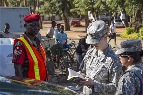 Capt. Arwyn Raina, brigade surgeon (left), and Spc. Kathryn Pollock, combat medic (right), 4th Infantry Brigade Combat Team, 1st Infantry Division, review an information guide book during a visit to the town of Salima, Malawi, July 16, 2014. The U.S. and other partner nations are working together to ensure they have a common ability to conduct peacekeeping and humanitarian support operations throughout Southern Africa.