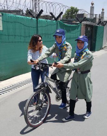 Marci Strathearn, left, teaches an Afghan girl scout how to ride a bike during an outreach event to empower young women. Strathearn, a former Army captain, has been in Afghanistan for the past 18 months trying to improve women's rights in the male-dominated country as an advisor for the U.S. Defense Department's Ministry of Defense Advisors program. She recently won a national award for her ongoing commitment to gender equality.