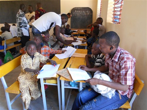 Military Intelligence Non-Commissioned Officer Course, 14-1, Ouagadougou, Burkina Faso, Chadian and Nigerien Students take an interest in student and orphan school assignments during a community relations event on November 30th, 2013.