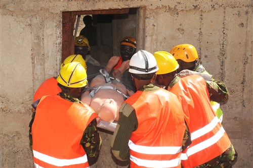 Members of Kenya’s Disaster Response Unit work together to safely extricate a victim through a confined space during a building collapse search and rescue course in Nairobi, Kenya, Nov. 27, 2013. The five-day course was used to increase the unit’s basic rescue skills and put them through various scenarios. Combined Joint Task Force-Horn of Africa supports partner nations in military-to-military engagements to defeat violent extremist organizations throughout East Africa.