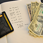 Financial planning spreadsheet and dollar bills.