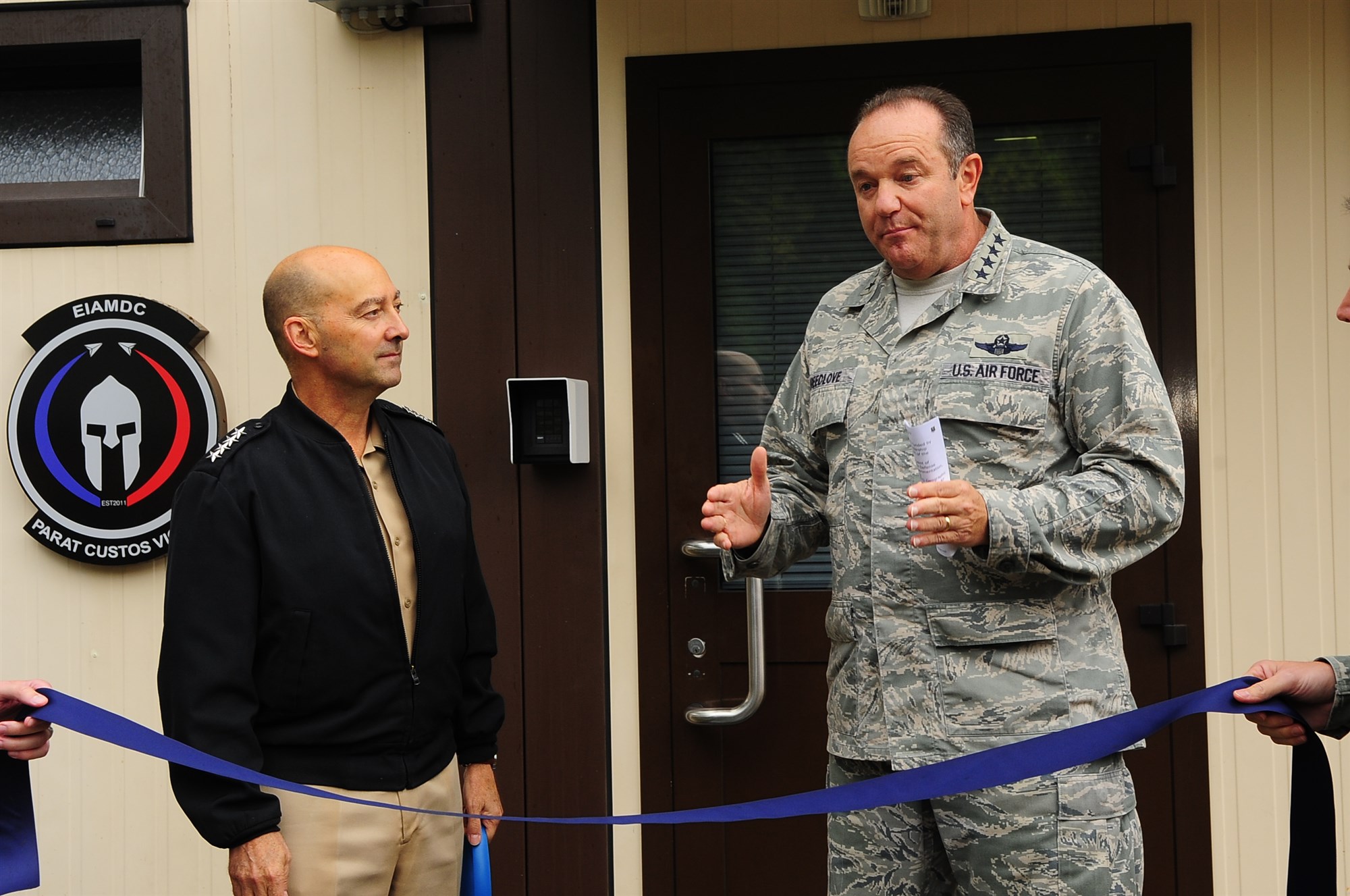 Admiral James Stavridis, Supreme Headquarters Allied Powers Europe commander, (left) looks on, as Gen. Philip M. Breedlove, Allied Air Command Ramstein commander, addresses NATO and senior leaders prior to the European Integrated Air and Missile Defense Center ribbon-cutting ceremony Sept. 26, 2012. The EIAMDC addresses increased education and training requirements driven by a new approach to missile defense and the emerging NATO territorial ballistic missile defense mission. 