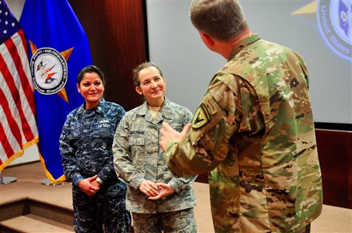 U.S. European Command Deputy Commander Lt. Gen. William Garrett III presents a coin to PO1 Riva Ali, left, and Master Sgt. Alicia Singerman, Secretary of the Joint Staff, for their outstanding duty performance.