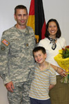 A Soldier receives an award with his family standing by his side.