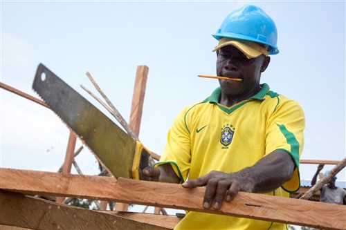 A local construction worker cuts a board while building a new Ebola treatment unit as part of Operation United Assistance in Greenville, Liberia, Dec. 4, 2014. United Assistance is a Department of Defense operation to provide command and control, logistics, training and engineering support to U.S. Agency for International Development-led efforts to contain the Ebola virus outbreak in West African nations. (U.S. Army Photo by Sgt. 1st Class Brien Vorhees, 55th Signal Company (Combat Camera)/Released)