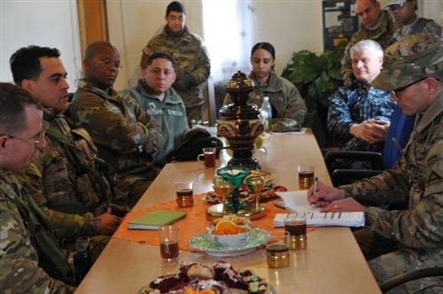 Multinational chaplains from the South African National Defense Force, U.S. Africa Command, 7th Army Joint Multinational Training Command and 2nd Cavalry Regiment listen to after-action notes from a Joint Multinational Readiness Center's observer, coach, trainer during Allied Spirit IV at 7th Hohenfels Training Area, Germany, Jan. 24, 2016.