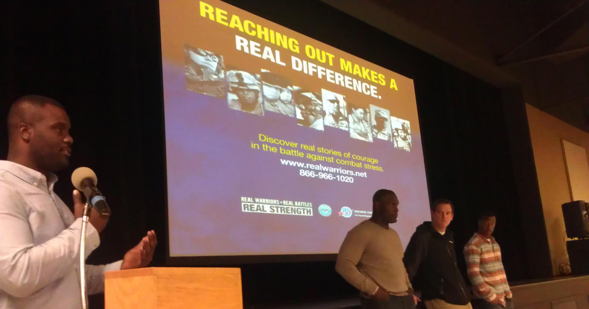 Four former NFL players stand in front of audience to speak