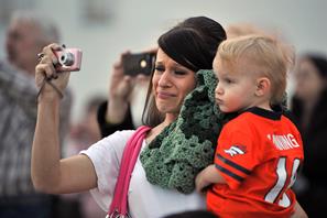 A military spouse and her son watch as her husband prepares to deploy