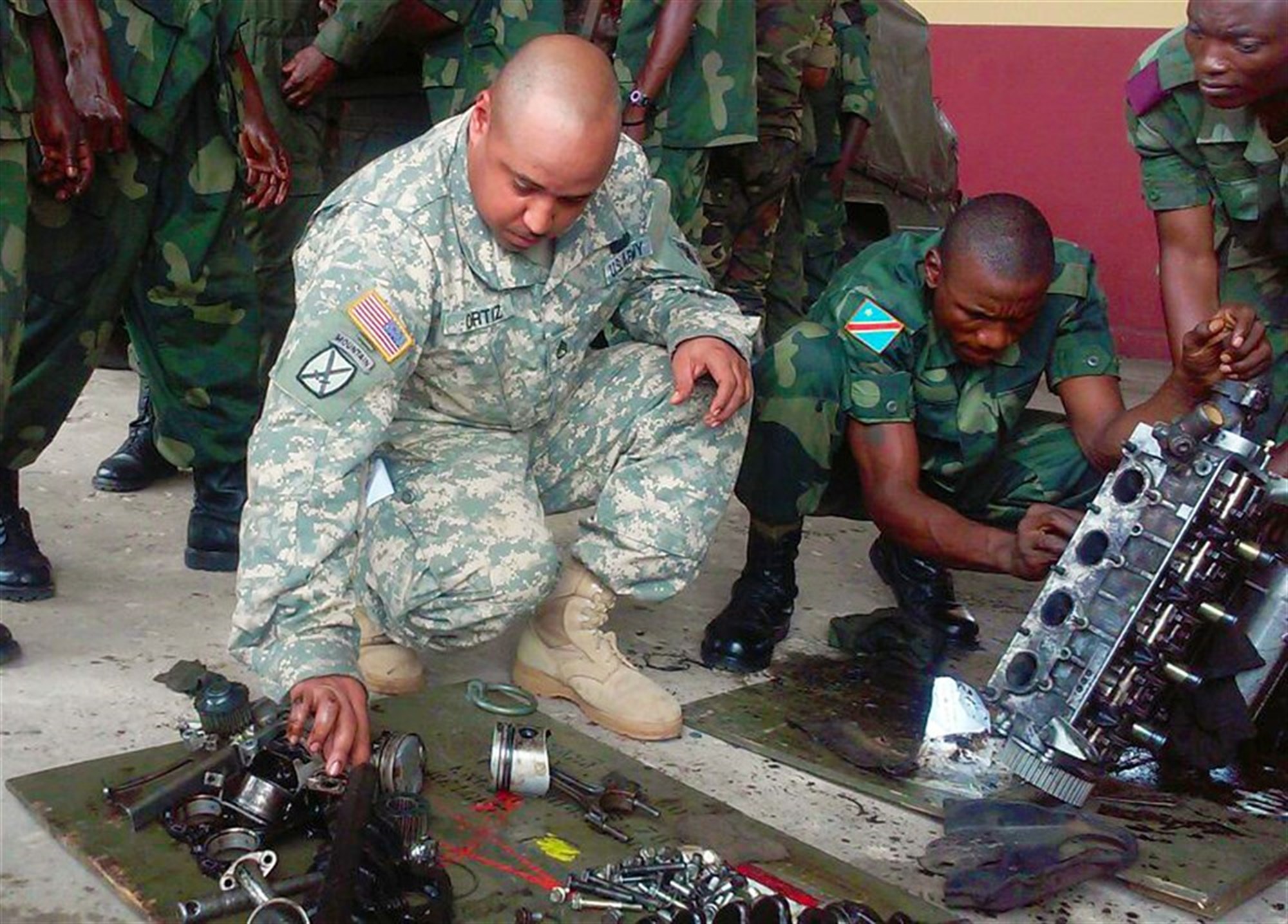 U.S. Army Africa's role in supporting training through the Democratic Republic of Congo's Defense Logistics School is an example of how AFRICOM can increase the capacity of partner nations to provide logistics support to their own forces. Here, Staff Sgt. Roberto Ortiz, a wheeled vehicle mechanic from AFRICOM’s Regionally Aligned Force, 3rd Brigade, 1st Armored Division from Fort Bliss, Texas, provides assistance to a DRC student rebuilding a light truck engine during hands on training at the DRC Logistics School. (U.S. Army Africa photo)