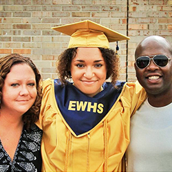 Family posing for photo with a high school graduate