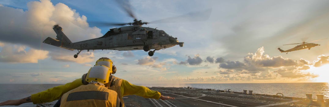 Sailors signal to an MH-60S Sea Hawk helicopter attached to the Golden Falcons of Helicopter Sea Combat Squadron (HSC) 12 as it hovers over the flight deck of the Arleigh-Burke-class guided-missile destroyer USS McCampbell (DDG 85).