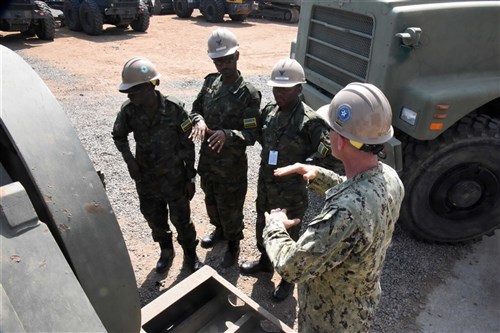 U.S. Navy Equipment Operator 2nd Class Tom Ross, Naval Mobile Construction Battalion 22, explains trailer detachment to Rwanda Defence Force engineers during their tour of Camp Lemonnier, Djibouti, Feb. 24, 2016. RDF members learned more about U.S. expeditionary camps and what equipment is used to build and maintain them. (U.S. Air Force photo by Staff Sgt. Victoria Sneed)