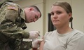 Army Pvt. Jonathan Bowen (left), health care specialist with the 1st Special Troops Battalion, 1st Cavalry Division Sustainment Brigade, provides an influenza vaccination to another Soldier. 