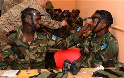 Djiboutian Army Cpl. Yosin, left, helps a fellow soldier, Mohamed, adjust his night vision goggle headmount during a night-vision goggle training course in Djibouti City, Djibouti, Oct. 10, 2016. Soldiers were tested on how quickly they could don their NVG gear during the class. (U.S. Air Force photo by Staff Sgt. Benjamin Raughton)