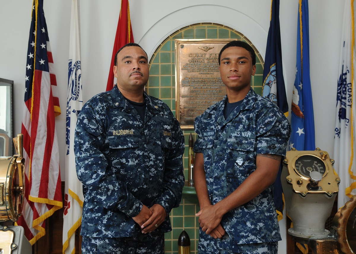 160719-N-FI568-001 PENSACOLA, Fla. (July 19, 2016) Chief Warrant Officer 2 Willie Walden-Bryan Sr.(left) and his son, Information Systems Technician Seaman Willie Walden-Bryan Jr., from Atlantic City, New Jersey, pose for a photo on the quarterdeck of the Center for Information Warfare Training.  U.S. Navy photo by Mass Communication Specialist 3rd Class Taylor L. Jackson/Released 