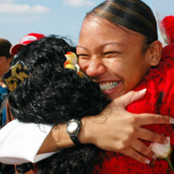 Service member coming back from deployment and hugging her child.