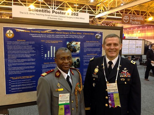 Dr. (Col.) Jean Diallo, chief of the ophthalmology department at the Burkinabe Military Base in Bobo-Dioulasso, Burkina Faso and Dr. (Col.) Darrel K. Carlton, director of clinical operations, ophthalmology services, Madigan Army Medical Center, Joint Base Lewis McChord, Wash., stand in front of their poster presentation during the American Academy of Ophthalmology Annual Meeting Nov. 18 at the Morial Convention Center in New Orleans, La. The poster highlights the success story of training Diallo to perform the small incision cataract surgery technique as well as details about how the U.S. Army is involved in reducing cataract blindness in developing worlds. (U.S. Army Africa photo) 