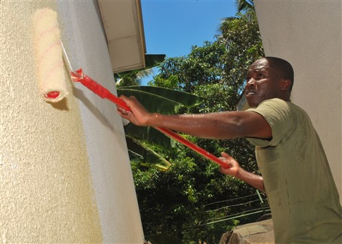 PORT VICTORIA, Seychelles - 2nd Lieutenant Gavin Kasyoka, a Kenya navy ship rider from Africa Partnership Station (APS) East platform USS Nicholas (FFG 47), places a fresh coat of paint on the main building of the Foyer De Nazareth, a children's orphanage in Port Victoria Seychelles, March 2, 2010.  APS is an international cooperative initiative aimed at strengthening global maritime partnerships through training and other collaborative activities in order to improve maritime safety and security in Africa, and is being conducted in cooperation with Commander, U.S. Naval Forces Africa and U.S. Africa Command (AFRICOM). (U.S. Navy photo by Petty Officer 3rd Class Tracey L. Whitley)