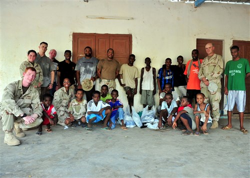 DJIBOUTI (Sept. 16, 2010) - Children of the National Center For the Protection of Juvenile Boys pose for a photo with volunteers of Combined Joint Task Force-Horn of Africa September 16, 2010. After a game of soccer, the volunteers presented the boys with new shoes collected from personnel around Camp Lemonnier. (U.S. Air Force photo by Staff Sergeant Kathrine McDowell) 