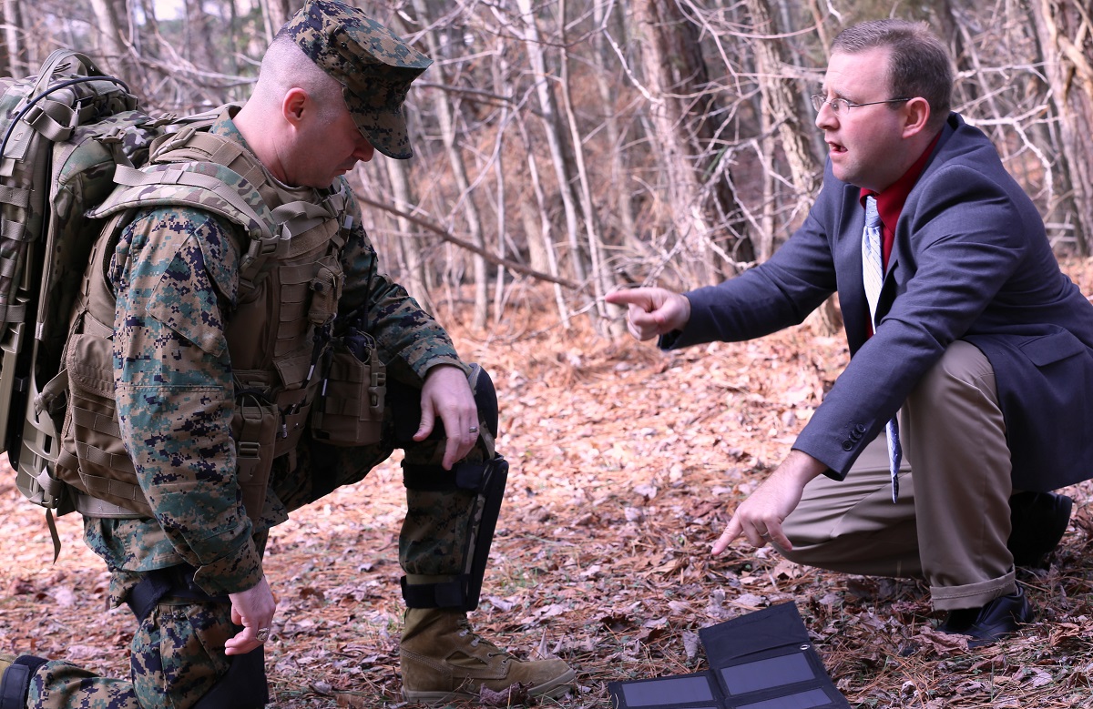 DAHLGREN, Va. - The Joint Infantry Company Prototype (JIC-P) solar panel is the topic of discussion between Marine Capt. Anthony Ripley and Eric South, Naval Surface Warfare Center Dahlgren Division technical lead for JIC-P. While Marines are on break during a march, they can pull out the solar panels and recharge batteries. The system features bionic and solar power enabling Marines and Soldiers to patrol longer without resupply.  