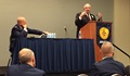 DHA director, Air Force Lt. Gen. Douglas Robb looks on as DHA Business Support Director, Joseph Marshall speaks at 2014 Association of Military Surgeons of the United States conference about joint business solutions.