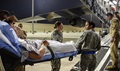Air Force Tech. Sgt. Erin Trueblood (center) and Air Force Staff Sgt. Luis Hernandez, 379th Expeditionary Medical Group Enroute Patient Staging Facility medical technicians, help load a patient onto a C-17 Globemaster III, at Al Udeid Air Base, Qatar. The patients was enroute to Landstuhl Regional Medical Center, Germany, to receive a higher level of care. (U.S. Air Force photo by Tech. Sgt. Carlos J. Treviño)