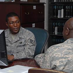 Two service members sitting across a desk, talking