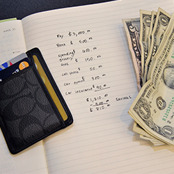 Handwritten monthly budget, wallet with credit cards and cash