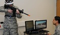 A behavioral health specialist aims his weapon during a demonstration provided by Maj. (Dr.) Michael Valdovinos to show how Virtual Reality Exposure Therapy can be be used to treat Post-Traumatic Stress Disorder by recreating the look, sounds and smells of a deployed environment. Photo Credit: Phil A. Jones 