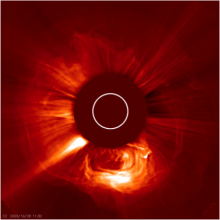 An image of a “halo” type CME surrounding the LASCO C2 occulting disk and a prominence eruption to the South of the Sun.  The white circle in the center is the size and location of the Sun, which is obscured by the occulting disk.  The bright linear feather to the lower left is a coronal streamer.  CMEs were observed to occur up to 6 times per day during the maximum of the solar cycle.  The halo is a CME headed toward Earth.