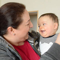 A woman holding a smiling little boy