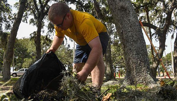 Seaman Christian Schwarzwaelder, assigned to air operations at Naval Station Mayport, cleans up debris caused by Hurricane Matthew. (U.S. Navy photo by Seaman Michael Lopez/Released)
