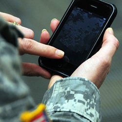 Service member holding a smart phone