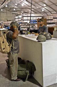 Man in civilian clothing tries on metal military helmet