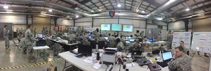 Many men and women in military uniforms working in classroom setting at exercise Vibrant Response